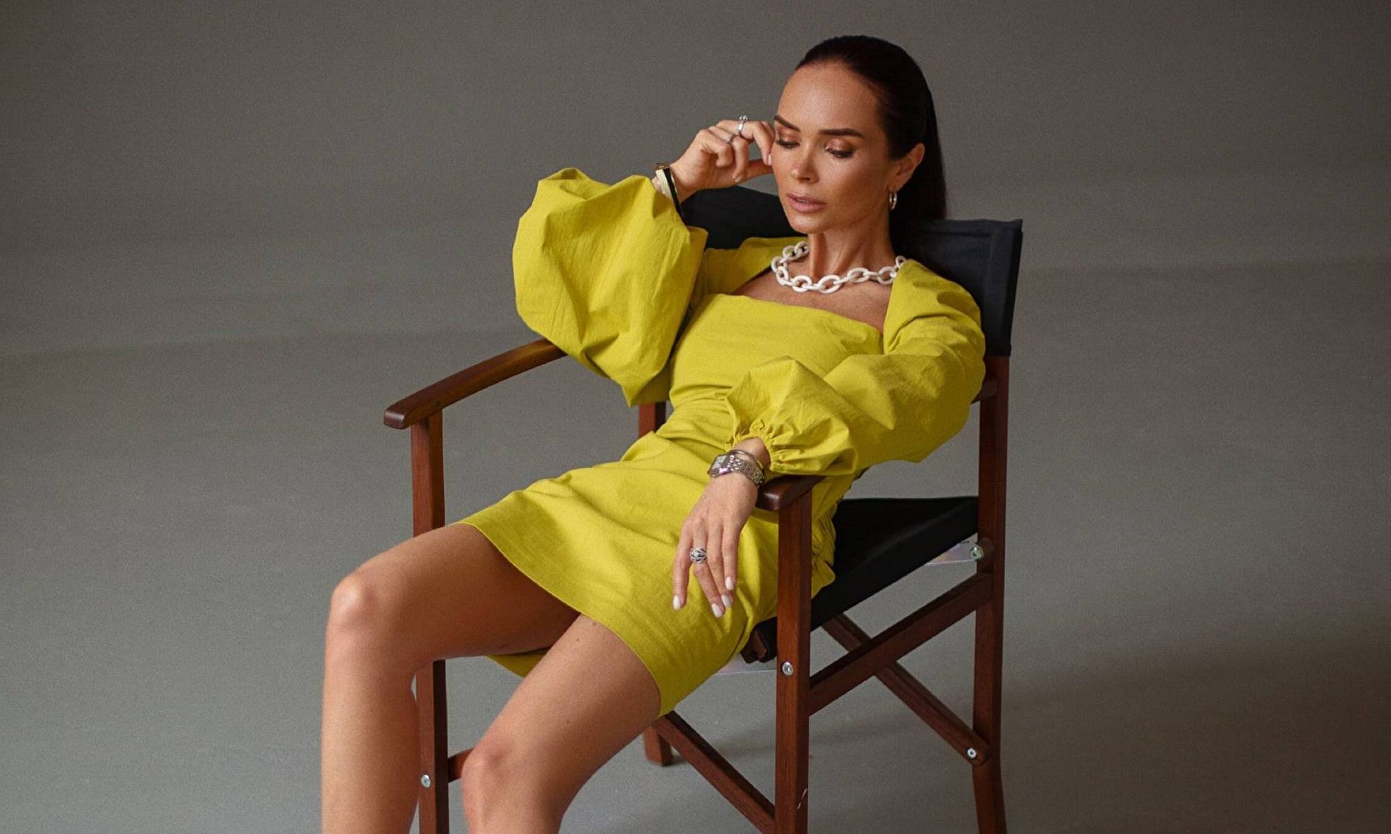 Виктория Зюлькова в желтом платье на стуле