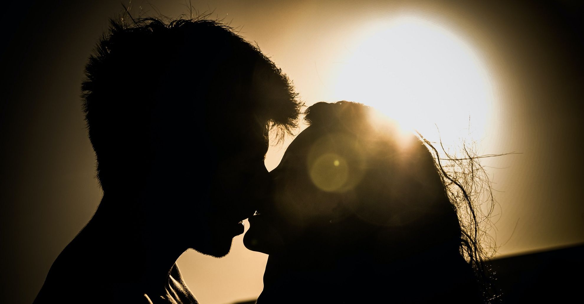 Мужчина и женщина целуются на закате