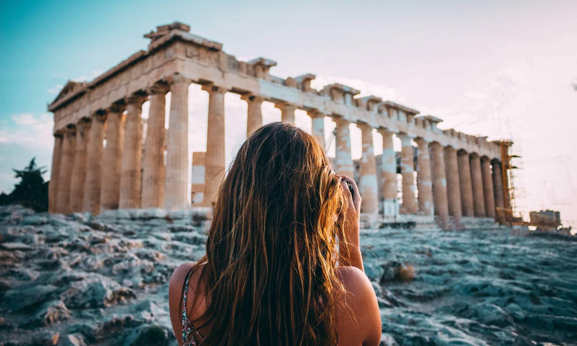 Девушка фотографирует достопримечательности в Греции
