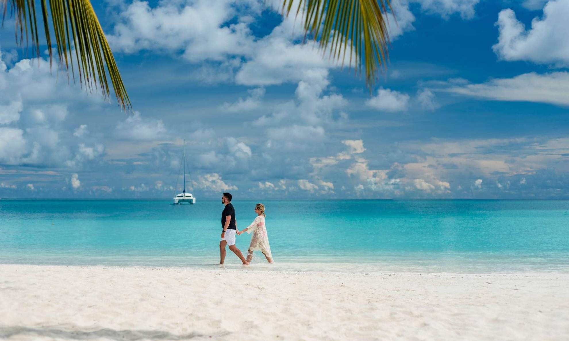 Пара прогуливается по пляжу на Мальдивах