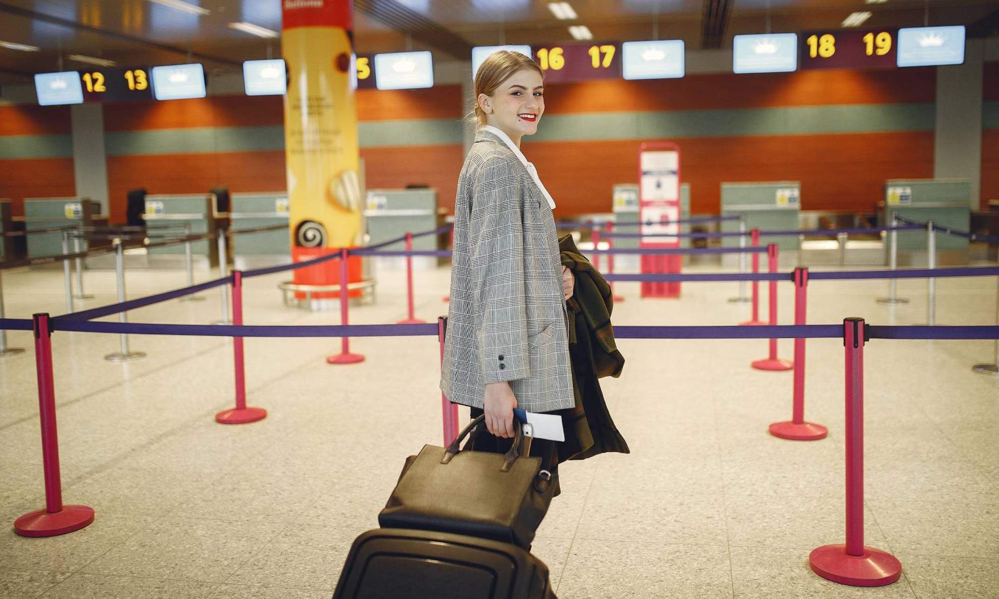 Девушка в аэропорту у стоек регистрации
