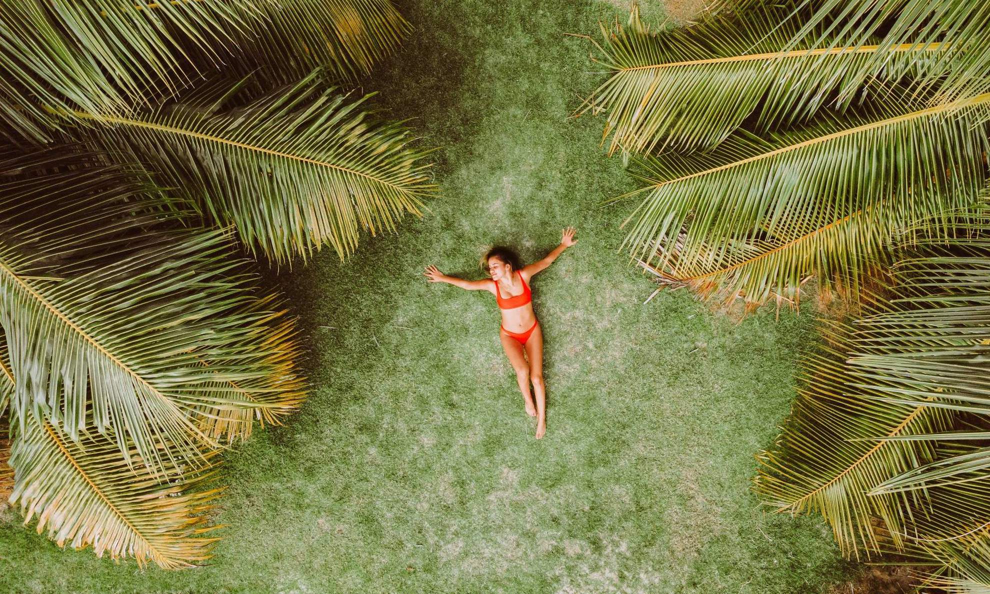 Девушка лежит под пальмами