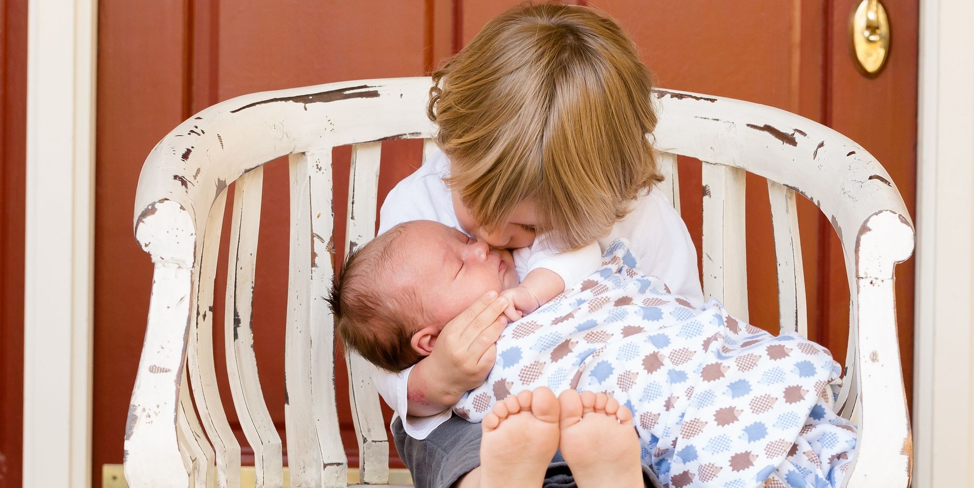 ребенок целует младенца