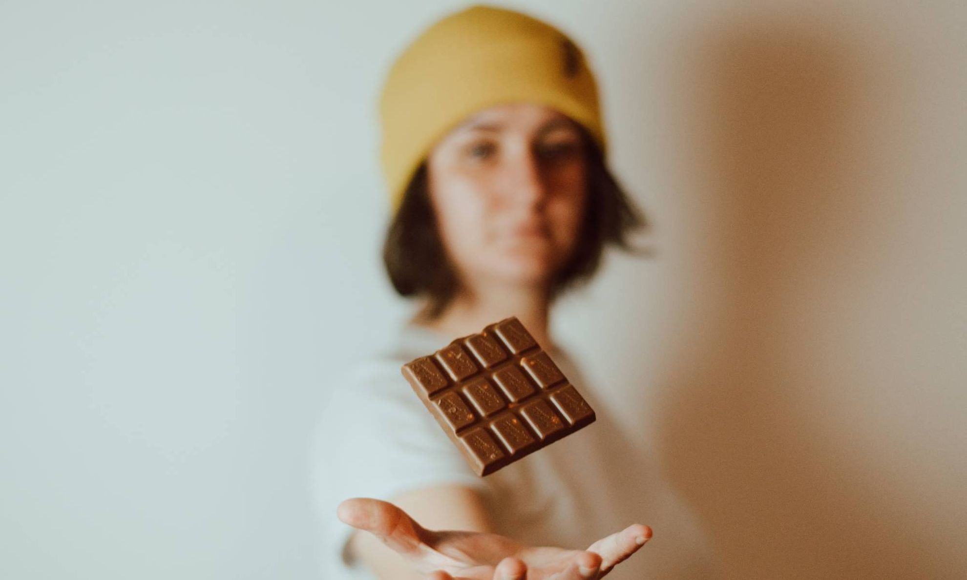 Девушка подбрасывает шоколадку в воздух